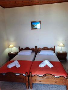 a bedroom with two beds with red sheets at Emilios see view Apartment in Barbati