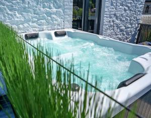 a jacuzzi tub in a yard with some grass at Gatsby River II in Yvoir