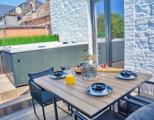 a wooden table on a balcony with a meal on it at Gatsby River II in Yvoir