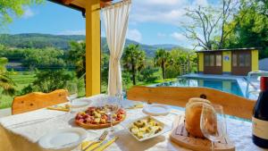 una mesa con comida y vino con vistas en Casa Valla, en Buzet