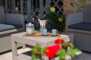 una mesa de centro con tazas y una batidora en el patio en Agriturismo Le Vigne, en Monticiano