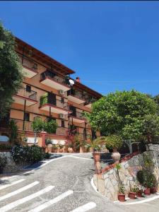 a large apartment building with trees and a road at Emilios see view Apartment in Barbati