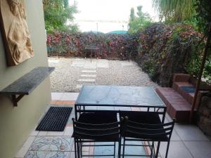 a patio with two chairs and a glass table at Marina Views Guesthouse in Hartbeespoort