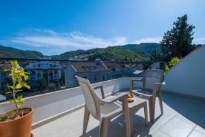 a balcony with two chairs and a table with a view at Sunrise City Residence in Fethiye