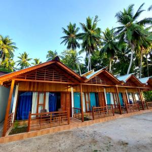 a row of resorts with palm trees in the background at Lemon Grass Resort & Spa in Havelock Island