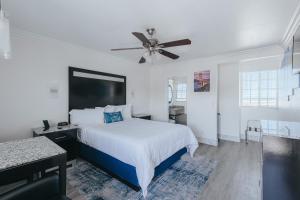 1 dormitorio con 1 cama y ventilador de techo en Sea Air Inn & Suites - Downtown - Restaurant Row, en Morro Bay