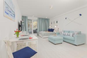 a white living room with a couch and a table at Rogowo Pearl Exclusive Apartments by Renters in Rogowo