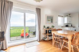 a kitchen and dining room with a large sliding glass door at Bell Rock Cottage - Sleeps 4 - Large Garden in St Andrews