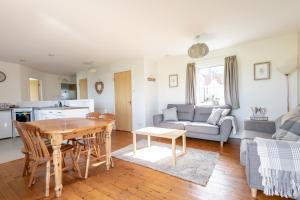 a kitchen and a living room with a table and a couch at Bell Rock Cottage - Sleeps 4 - Large Garden in St Andrews