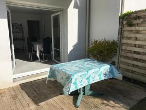 un banco sentado en el porche de una casa en Appartement + Jardin, en Fouesnant