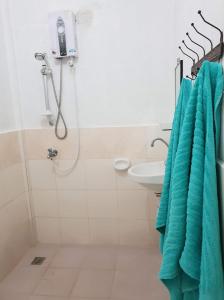 ein Bad mit einer Dusche und einem Waschbecken in der Unterkunft Nida's Place in General Luna