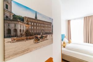 a picture of a man riding a horse drawn carriage on a street at Cityhotel Trumer Stube in Salzburg