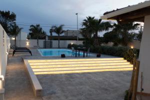 een achtertuin met een zwembad en een hoop licht bij MrBrown - Cinzia Resort Beach in Mazara del Vallo