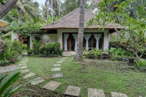 a small house in the middle of a garden at Rumah Kelapa Sepi in Karangasem