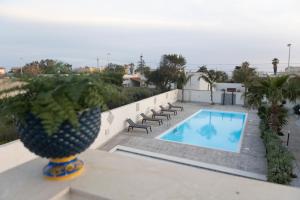 a villa with a swimming pool and a vase at MrBrown - Cinzia Resort Beach in Mazara del Vallo