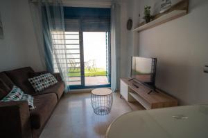 salon z kanapą i telewizorem w obiekcie Apartamento Los Patos Beach w mieście Benalmádena