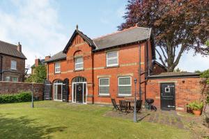 an exterior view of a brick house with a yard at Southport Coach House in Southport