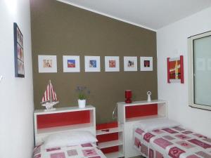- une chambre avec 2 lits et des photos sur le mur dans l'établissement Villa La fenice, à Granelli