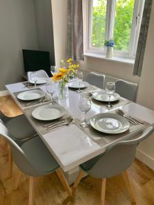 a table with plates and wine glasses on it at An ENTIRE 2beds, 2bathrooms, free Wifi, Free Parking, Oxford in Oxford