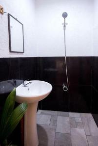 ein Badezimmer mit einem weißen Waschbecken und einem Spiegel in der Unterkunft Nida's Place in General Luna