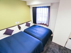 Rúm í herbergi á HOTEL LiVEMAX Niigata Ekimae