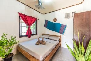 a bedroom with a bed with shoes on it at Nida's Place in General Luna