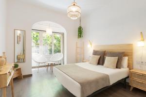 バルセロナにあるKey Family Cozy Homeの白いベッドルーム(大型ベッド1台、テーブル付)