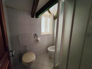 a small bathroom with a toilet and a window at Albis Harena - Ibiscus Attico Ocean View in Santa Maria