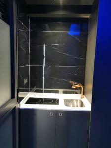 Una pequeña cocina con estufa y fregadero. en Lexury Suite Acqua, en Babilafuente