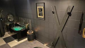 een badkamer met een bad en een wastafel met een spiegel bij La Suite Maléfik in Maing