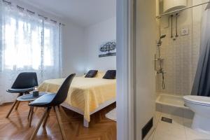 1 Schlafzimmer mit einem Bett, 2 Stühlen und einem WC in der Unterkunft Guest House Anna in Mlini