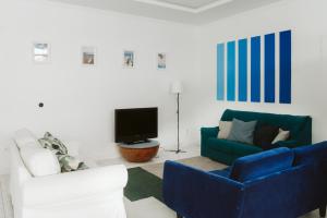 a living room with a blue couch and a tv at KYO Surf Hostel in Las Palmas de Gran Canaria