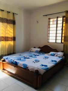 a bedroom with a bed with a blue comforter at Mikocheni Home stay in Dar es Salaam