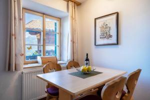 een eetkamer met een tafel en stoelen en een raam bij Ferienwohnung Brunjaunhof in Schenna