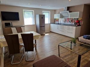 a kitchen and living room with a table and a refrigerator at Ferienwohnung Alte Linde in Hardheim