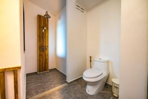 a bathroom with a toilet and a wooden door at Hidden Beach Resort in Ko Mak