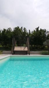 eine Couch neben einem Pool in der Unterkunft Sotto La Vigna Charm Stay Adults only vacation Suite in Montegrosso dʼAsti