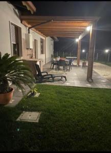 a patio at night with a table and chairs at La dolce vita in Scanzano