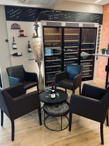 MondercangeにあるHotel Monvillageの椅子、テーブル、ワインラック付きの待合室