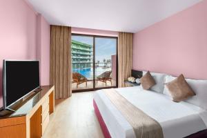 um quarto com uma cama, uma televisão e uma varanda em voco Monaco Dubai, an IHG Hotel, Adults Only, World Islands em Dubai