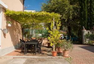 un patio con mesa negra, sillas y plantas en Il Vigneto Affittacamere, en Manerba del Garda