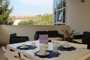 een eetkamer met tafels en stoelen en een groot raam bij Il Pozzo in San Benedetto del Tronto