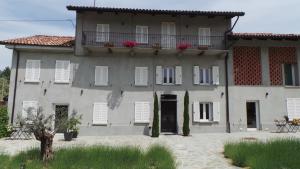 a large house with white windows and a balcony at Sotto La Vigna Charm Stay Adults only vacation Suite in Montegrosso dʼAsti