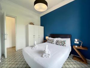 a blue bedroom with a large bed with white sheets at Stay U-nique Apartments Comte Urgell in Barcelona