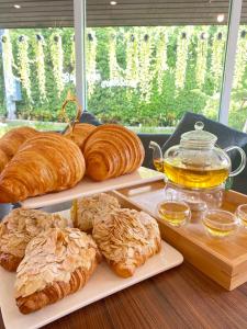 un tavolo con tre piatti di pasticcini e una brocca di miele di Preme village a Ubon Ratchathani