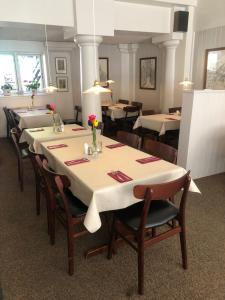 a dining room with tables and chairs with flowers on them at Restaurant Backhaus in Ribe