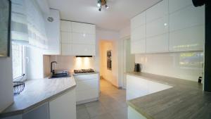 uma cozinha com armários brancos e um fogão em Apartamenty EverySky - Konstytucji 3 go Maja 66-1 em Karpacz