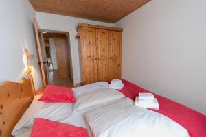 a large bed in a room with red and white sheets at Apartment Panorama Gerlitzen in Treffen