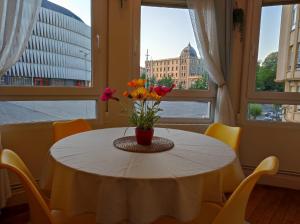 una mesa con un jarrón de flores en una habitación con ventanas en Stadium corner, en Bilbao