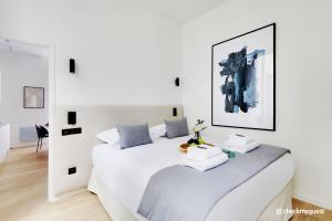 ein weißes Schlafzimmer mit einem großen weißen Bett in der Unterkunft CMG - Place des Vosges / Turenne in Paris